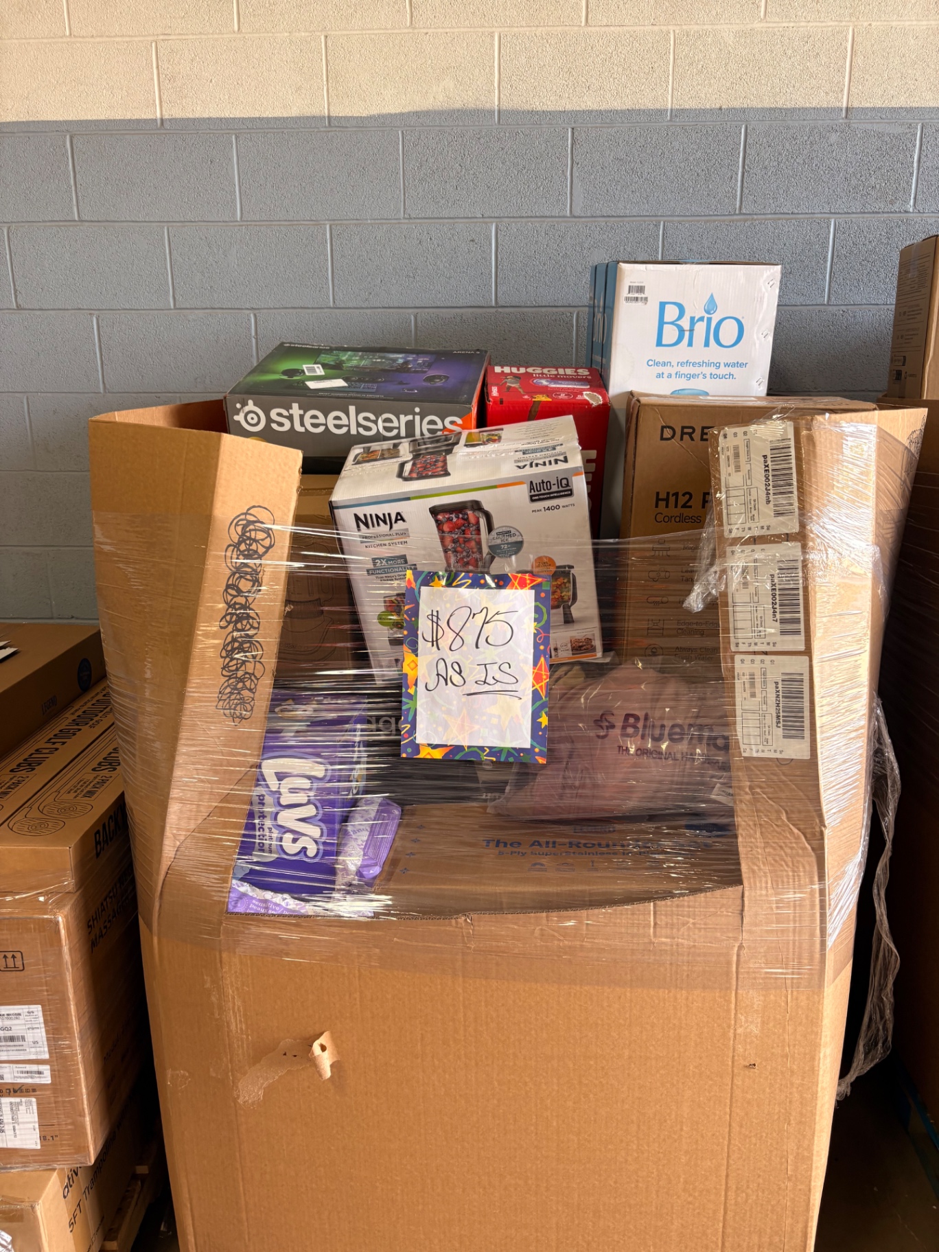 Boxed wholesale merchandise staged on the Nest Pointe warehouse floor