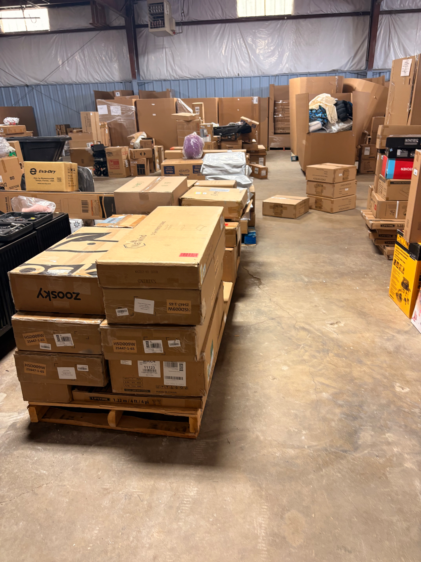 Mixed merchandise pallets and boxed inventory inside the Nest Pointe warehouse